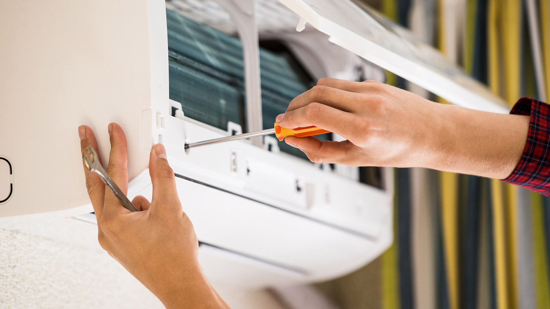 close up of hands using screw driver on ac unit oakland park fl