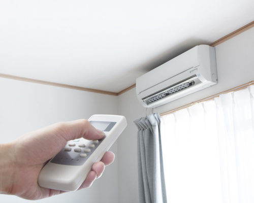 person turning on ac in corner of room with remote oakland park fl