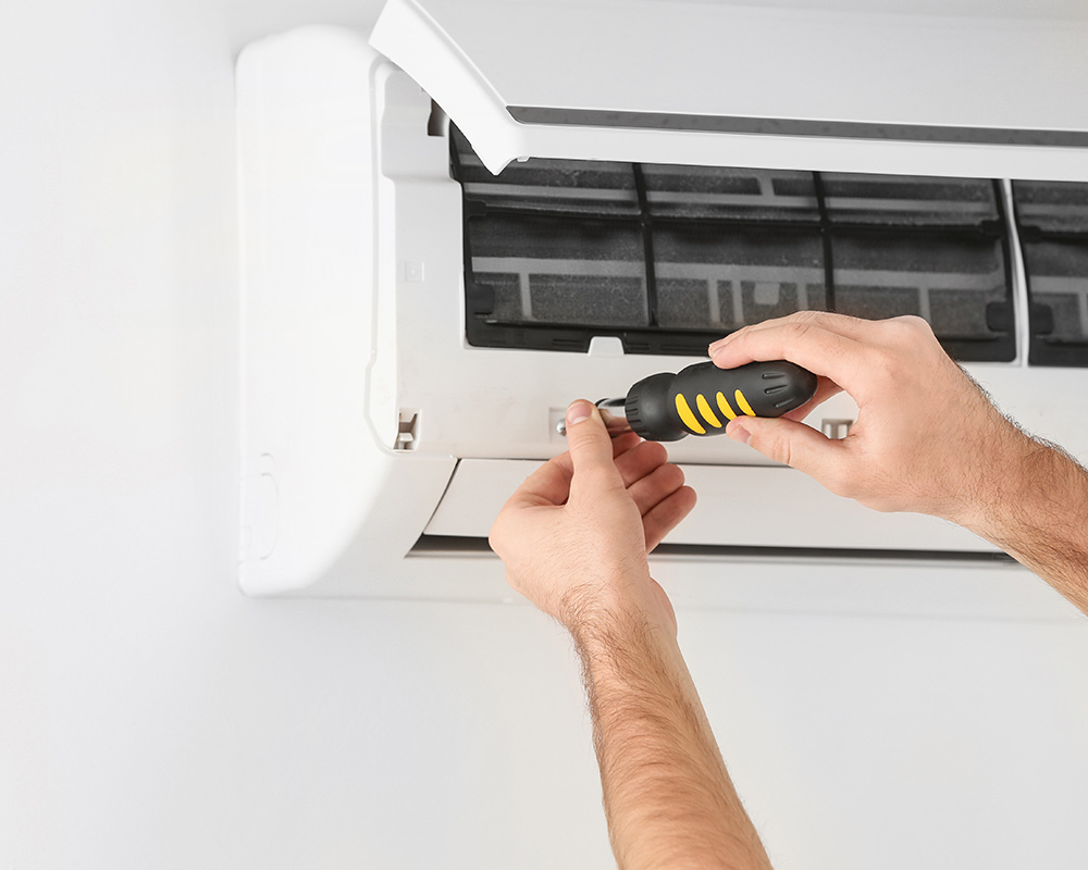 person using screwdriver on ac unit oakland park fl